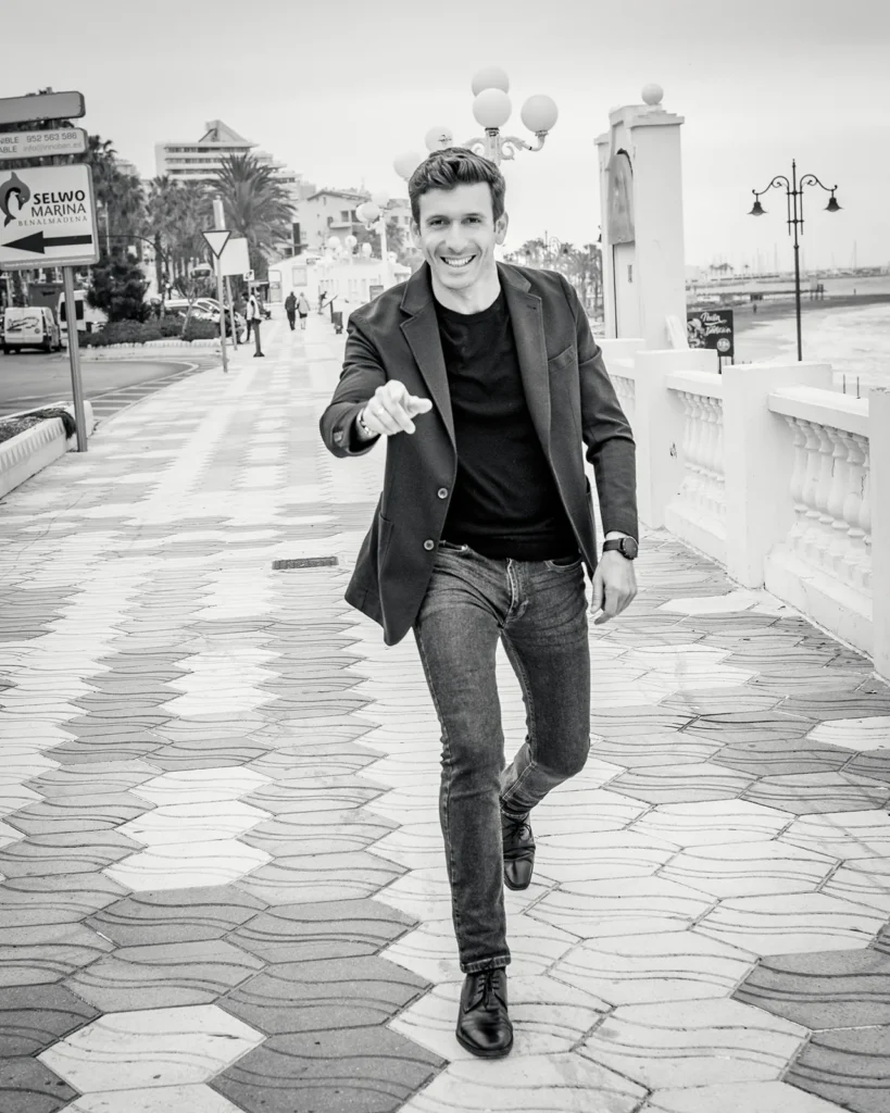 Javier Nicolas caminando por el paseo de Benalmádena junto a la playa en un retrato en blanco y negro.